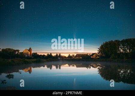 Dobrush, Weißrussland. Komet Neowise C2020f3 In Der Nacht Sternenhimmel Reflektiert In Kleinen See Gewässern. Stockfoto