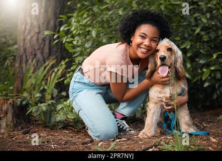 Hes der beste Junge. Ganzkörperportrait einer attraktiven jungen Frau und ihres Cocker Spaniel Welpen draußen. Stockfoto