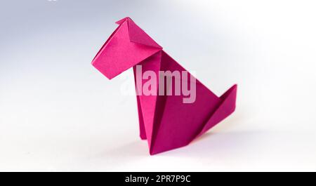 Rosa Papierhund Origami isoliert auf weißem Hintergrund Stockfoto