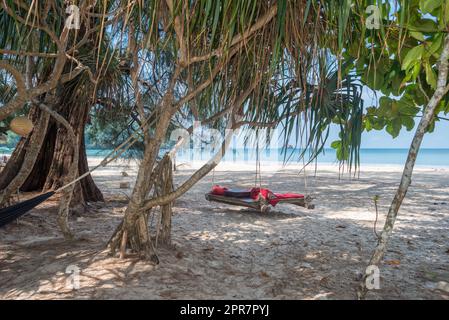 Hängematte und Schaukelbett unter Schraubenpalmen am Strand Ao Yai auf Ko Phayam in Thailand Stockfoto