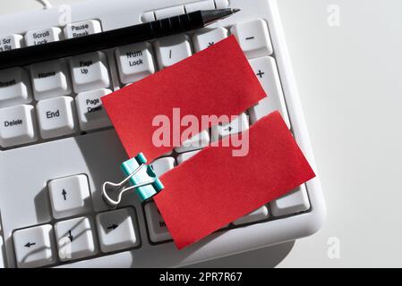 Gerippte Haftnotiz Mit Wichtigen Nachrichten Über Tastatur Und Stift Auf Dem Schreibtisch. Zerriss Ein Memo Mit Zwei Verschiedenen Informationen. Aktuelle Ankündigungen Präsentiert. Stockfoto