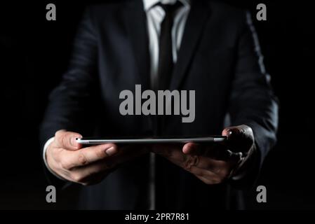 Geschäftsmann, Der Ein Tablet Mit Beiden Händen Hält Und Wichtige Daten Präsentiert. Mann Im Anzug, Der Grausame Informationen Zeigt. Leitende Führungskraft Zeigt Die Grausame Ankündigung. Stockfoto