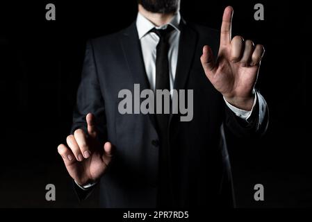Ein Geschäftsmann, Der Mit Zwei Fingern Auf Grausame Informationen Zeigt. Mann Im Anzug Präsentiert Aktuelle Updates. Geschäftsleitung Zeigt Wichtige Ankündigungen. Unternehmer Zeigen Neue Ideen Stockfoto