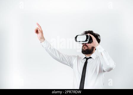 Mann Trägt Eine Vr-Brille Und Zeigt Mit Einem Finger Auf Wichtige Nachrichten. Ein Geschäftsmann, Der Eine Brille Zur Virtuellen Realität Hat Und Grausame Informationen Zeigt. Stockfoto