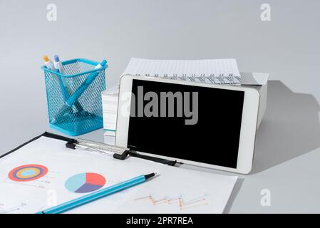 Wichtige Nachrichten Werden Am Telefon Am Schreibtisch Mit Bleistiften, Büchern Und Klemmbrett Herum Präsentiert. Auf Dem Handy Auf Dem Tisch Mit Notizbüchern Und Stiften Gezeigte Crutial Inforations. Stockfoto