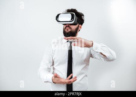 Mann Trägt Eine Vr-Brille Und Präsentiert Wichtige Botschaften Zwischen Den Händen. Ein Geschäftsmann, Der Eine Brille Zur Virtuellen Realität Hat Und Grausame Informationen Zeigt. Stockfoto