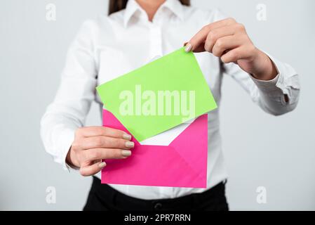 Elegante, Professionelle Frau, Die Einen Brief Mit Wichtigen Informationen In Einen Umschlag Legt. Geschäftsfrau Mit Postkarte, Die Wichtige Nachrichten Per Post Sendet. Stockfoto