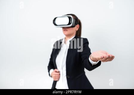 Frau Trägt Eine Vr-Brille Und Präsentiert Wichtige Botschaften Mit Einer Hand. Eine Geschäftsfrau Mit Einer Brille Für Die Virtuelle Realität, Die Über Palm Grausame Informationen Zeigt. Stockfoto