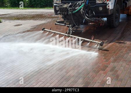 Eine spezielle Maschine wäscht Stadtwege und Straßen mit Wasser Stockfoto