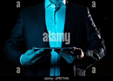 Geschäftsmann, Der Ein Tablet Mit Beiden Händen Hält Und Wichtige Daten Präsentiert. Mann Im Anzug, Der Grausame Informationen Zeigt. Leitende Führungskraft Zeigt Die Grausame Ankündigung. Stockfoto