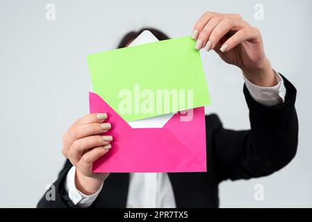 Hände Einer Geschäftsfrau, Die Wichtige Briefe In Umschläge Legt, Um Sie Per Post Zu Versenden. Frau Trägt Anzug Mit Postkarte Mit Wichtigen Geschäftsinformationen Und Nachrichten. Stockfoto
