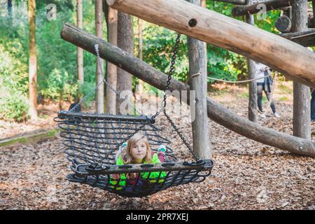 Teenager, die auf einer Schaukel im Zoo von Ljubljana schwingt Stockfoto