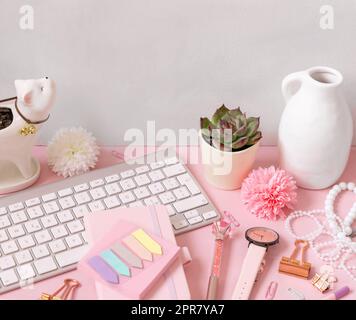 Tastatur und pinkfarbene Schulmädchen-Accessoires auf pastellrosa Nahaufnahmen Stockfoto