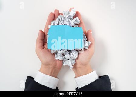 Geschäftsfrau Mit Papierfolien Und Wichtiger Botschaft Oben. Frau Mit Zerknitterten Notizen Und Grausamen Informationen In Den Händen. Handflächen Voll Mit Faltenschreiber Und Memo. Stockfoto