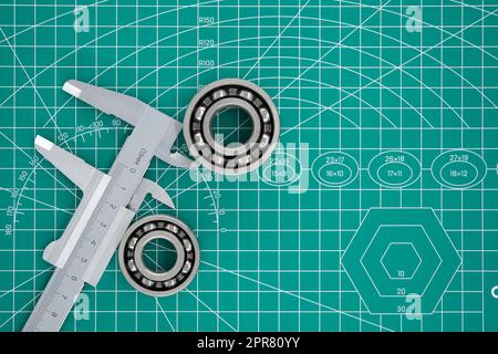 Gruppe von Rollenlagern und Bremssattel auf Schneidmatte Stockfoto