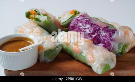 Vietnamesische Frühlingsrollen Goi Cuon oder Nem Cuon, gefüllt mit Garnelen, Kräutern, Reis vermicelli und Gemüse. Serviert mit Hoisin und Erdnusssoße Dip. Stockfoto