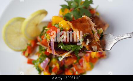 Glasiertes Lachsfilet mit Mango-Salsa, Kräutern und Zitrone Stockfoto