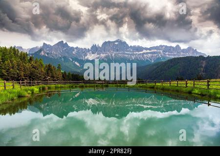 Rosengarten (Catinaccio) Bergkette, die sich in einem kleinen Bergsee spiegelt, Tiers-Tires, Trentino-Alto Adige/Sudtirol, Italien Stockfoto