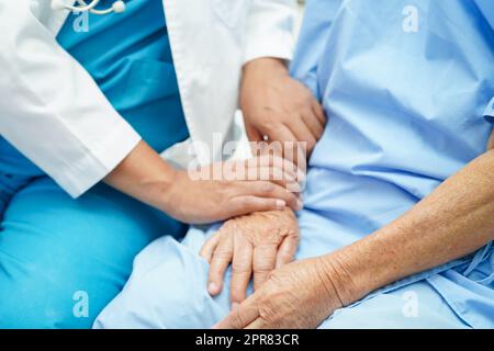 Arzt kümmert sich, hilft und ermutigt asiatische ältere Frau Patientin im Klinikspital. Stockfoto