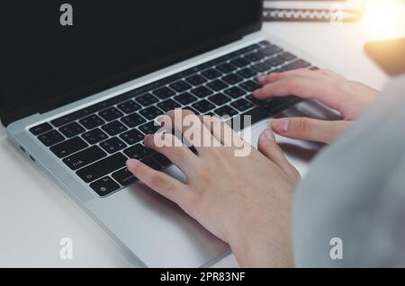 Nahaufnahme Hand Frau Eingabe Tastatur Computer Laptop auf dem Schreibtisch.Business-Technologie online und Kommunikation auf dem Schreibtisch. Stockfoto