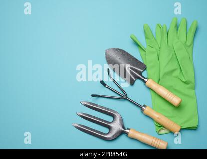 Gartenwerkzeuge zur Beetbearbeitung im Garten und gummierte grüne Handschuhe Stockfoto