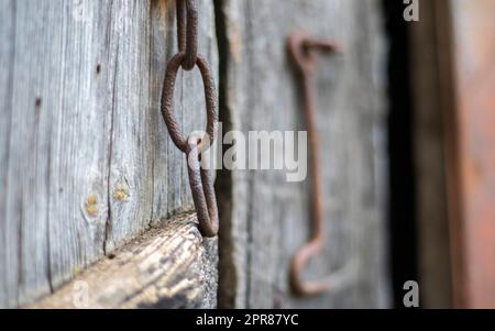 Isoliertes altes rostiges Türschloss an einer Holztür. Nahaufnahme. Problematische verwitterte Platten. Hintergrund der alten Wandtextur. Detail einer alten Holztür mit Stockfoto