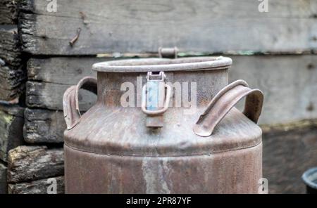 Eine alte rostige Metalldose auf dem Land. Behälter für den Transport von Flüssigkeiten, Milch oder flüssigen Kraftstoffen mit mehreren Griffen. Milchbank in zylindrischer Form mit weitem Hals. Flasche mit versiegeltem Verschluss. Stockfoto