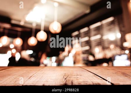 Hintergrund mit altem Holzterrassentisch vor der verschwommenen Bar oder Restaurant Stockfoto