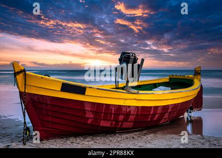 Sonnenuntergang über der Ostsee mit Fischerboot am Strand - Debki, Pommern, Polen Stockfoto