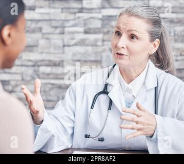 Informiert sich gründlich über alle ihre Verfahren. Aufnahme eines Arztes, der eine Konsultation mit einem Patienten in einer Arztpraxis hat. Stockfoto