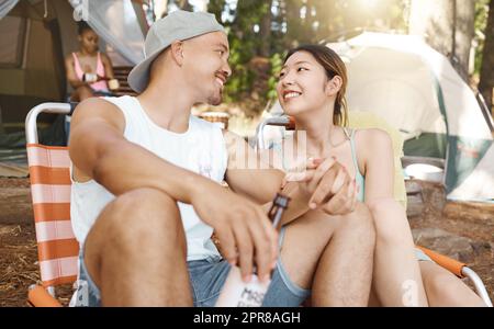 Du bist so perfekt für mich. Aufnahme eines jungen Paares, das zusammen sitzt und sich beim Campen im Wald verbindet. Stockfoto