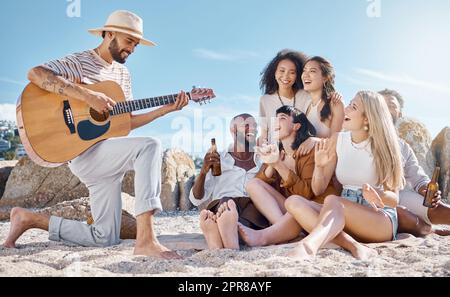 Sind meine Freunde gute Zuhörer überprüft. Aufnahme eines Mannes, der Gitarre spielt, während seine Freunde am Strand mitsingen. Stockfoto