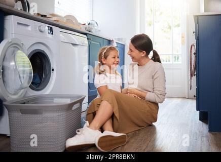 Nun haben Sie Ihre Lieblings-Kleid sauber und bereit, bald zu tragen. Eine Frau sitzt mit ihrer Tochter, während die Wäsche zu Hause. Stockfoto