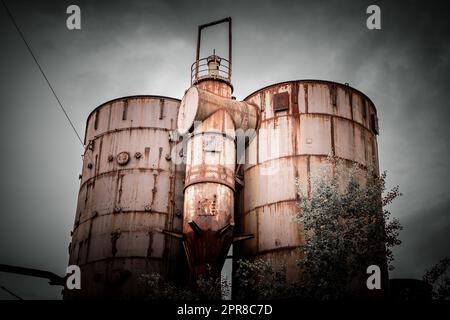 Die zwei rostigen Industrietanks einer alten Fabrik in Deutschland. Stockfoto