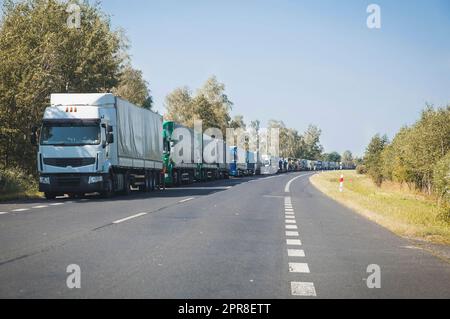 Endlose Lkw-Kolonne auf der Herbststraße Stockfoto