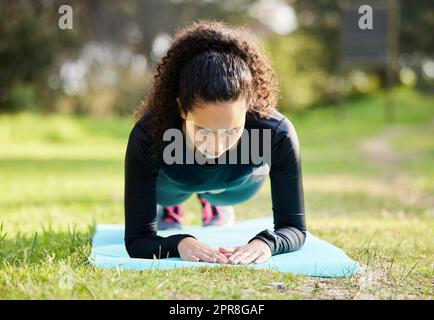 Kanalisieren Sie Ihre innere Stärke. Aufnahme einer jungen Frau, die ihren morgendlichen Yoga draußen genießt. Stockfoto