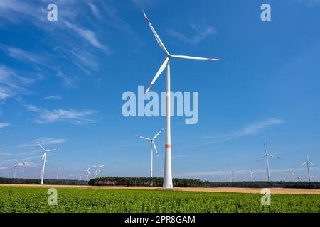 Windenergieanlagen vor blauem Himmel in Deutschland Stockfoto