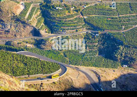 Wunderschöne Landschaft eines kleinen landwirtschaftlichen Dorfes an einem sonnigen Nachmittag in der Nähe einer Autobahn oder einer verkehrsreichen Straße für Logistik oder Transport von Gütern. Bananenplantagen in der Stadt Los Llanos, La Palma, Spanien Stockfoto