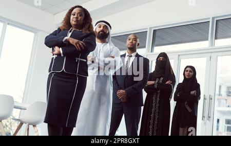 Sie handeln erfolgreich. Aufnahme einer Gruppe von Geschäftskollegen, die in einer einzigen Zeile in ihrem Unternehmensbüro stehen. Stockfoto