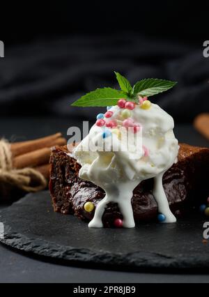 Gebackene Brownie-Schokoladenstückchen auf einem schwarzen Tisch Stockfoto