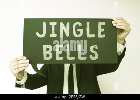 Textunterschrift mit Jingle Bells. Ein Wort, das auf den berühmtesten traditionellen Weihnachtsliedern der Welt geschrieben wurde. Ein Geschäftsmann, der eine Sprechblase mit wichtigen Informationen hält. Stockfoto