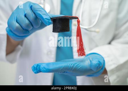 Asiatische Arzt Studie lernen mit Abschluss GAP Hut in Krankenhausstation, clever hell Genie Bildung Medizin Konzept. Stockfoto