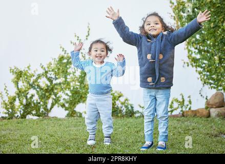 Waren so glücklich, den Tag draußen zu verbringen. Aufnahme von zwei kleinen Mädchen, die draußen zusammen spielen. Stockfoto