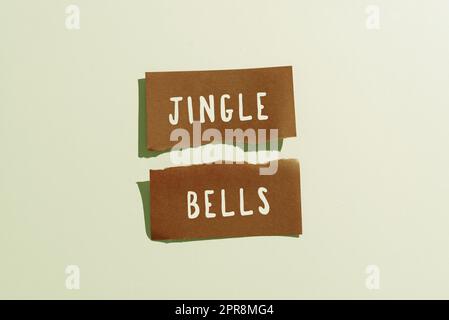 Textunterschrift mit Jingle Bells. Business Concept weltweit berühmtester traditioneller Weihnachtssong gerissener Haftnotiz mit wichtigen Nachrichten auf dem Schreibtisch. Stockfoto