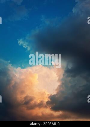 Wunderbare Sturmwolken, sonnenbeleuchtet mit einem goldenen Licht, wie aus dem Himmel zu kommen. Traumhafter Himmel, vertikaler himmlischer Hintergrund Stockfoto