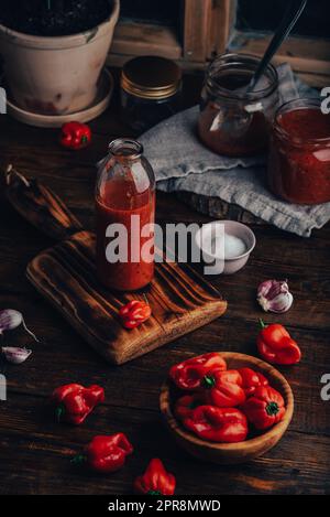 Frisch gekochte heiße Chilisauce mit Habanero-Paprika, Paprika, Tomaten und Knoblauchzehen Stockfoto