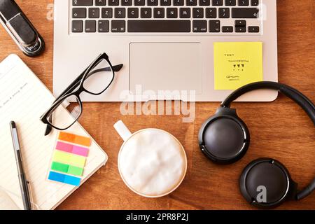 Nehmen Sie nicht alles mit. Ein leeres Büro mit einem Laptop und Kopfhörern auf dem Schreibtisch. Stockfoto