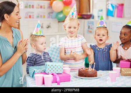 Singen zum Geburtstagskind. Die Kinder im Vorschulalter feiern den Geburtstag in der Klasse. Stockfoto