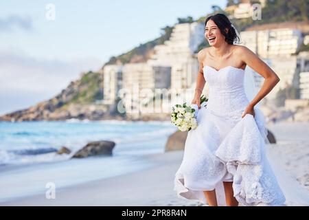 Im keine auslaufende Braut. Eine schöne Frau am Strand an ihrem Hochzeitstag. Stockfoto