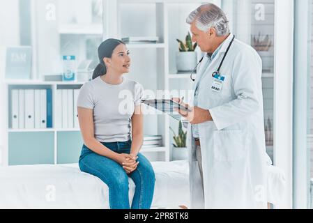 Ist Ihre Information auf dem neuesten Stand. Ein Arzt, der eine Patienteninformation auf seinem medizinischen Chart aufzeichnet. Stockfoto